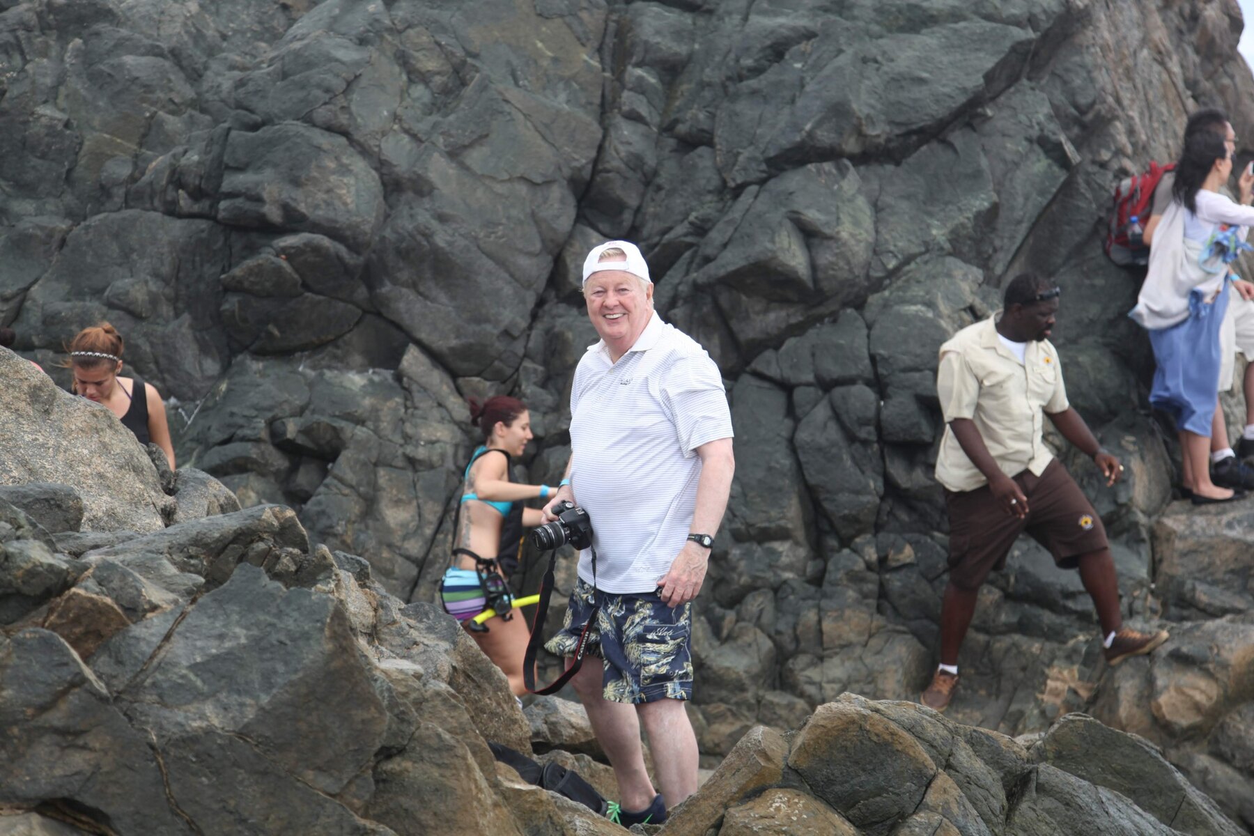 Tom Snyder smiling during a visit to a rocky shoreline